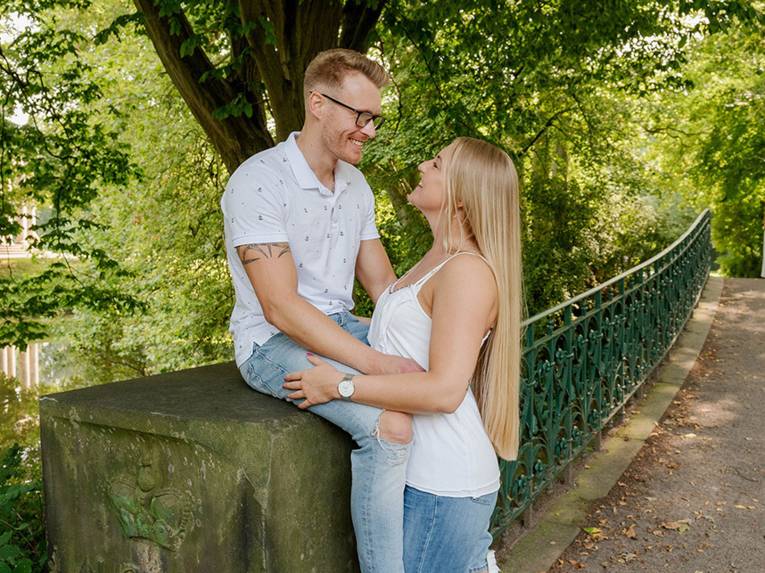 Zwei Personen auf einer Brücke im Grünen.